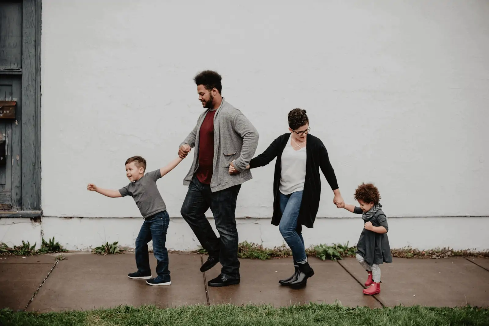 Family of four walking on a rainy sidewalk