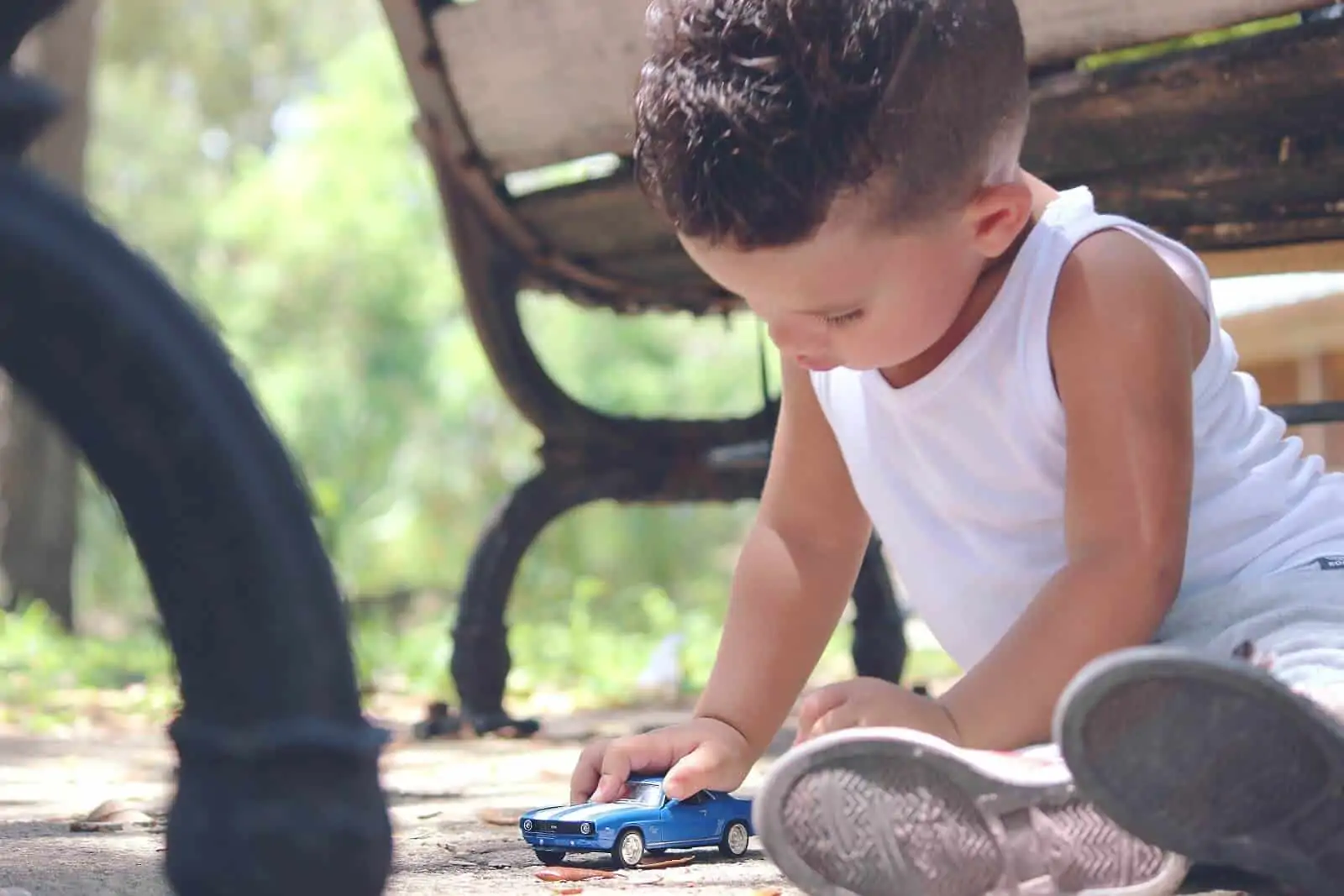 Little boy playing with blue car