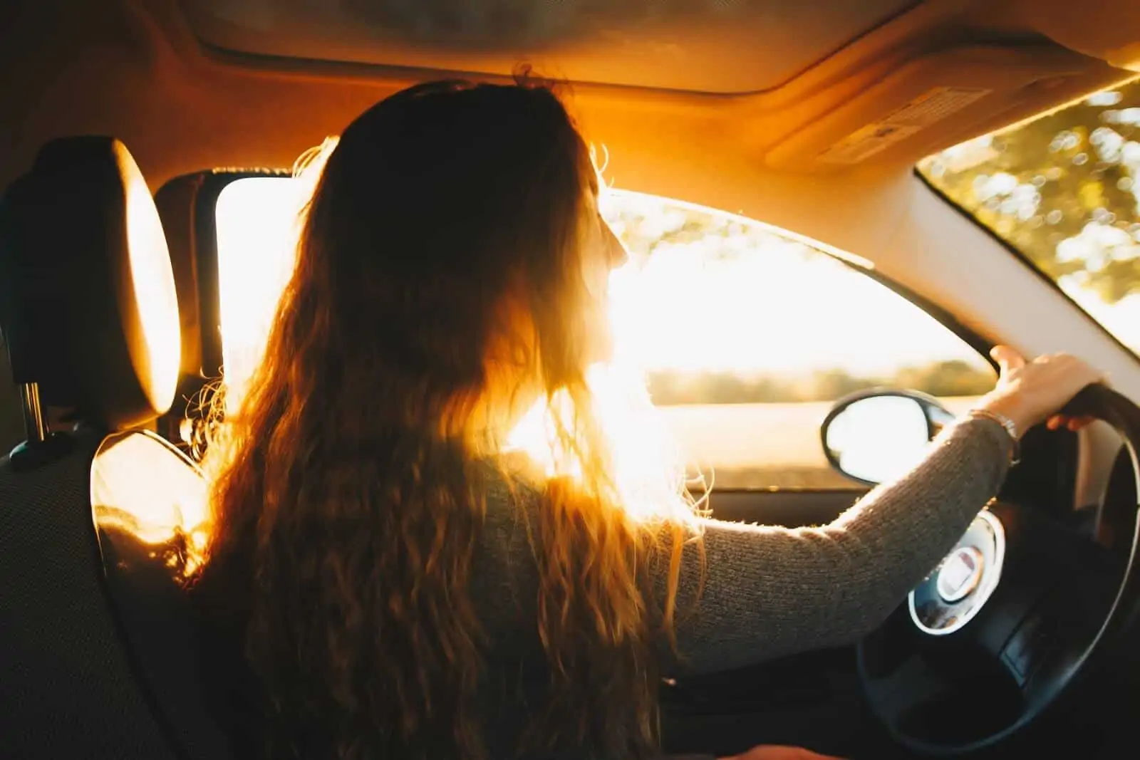 Girl driving with sun streaming into car