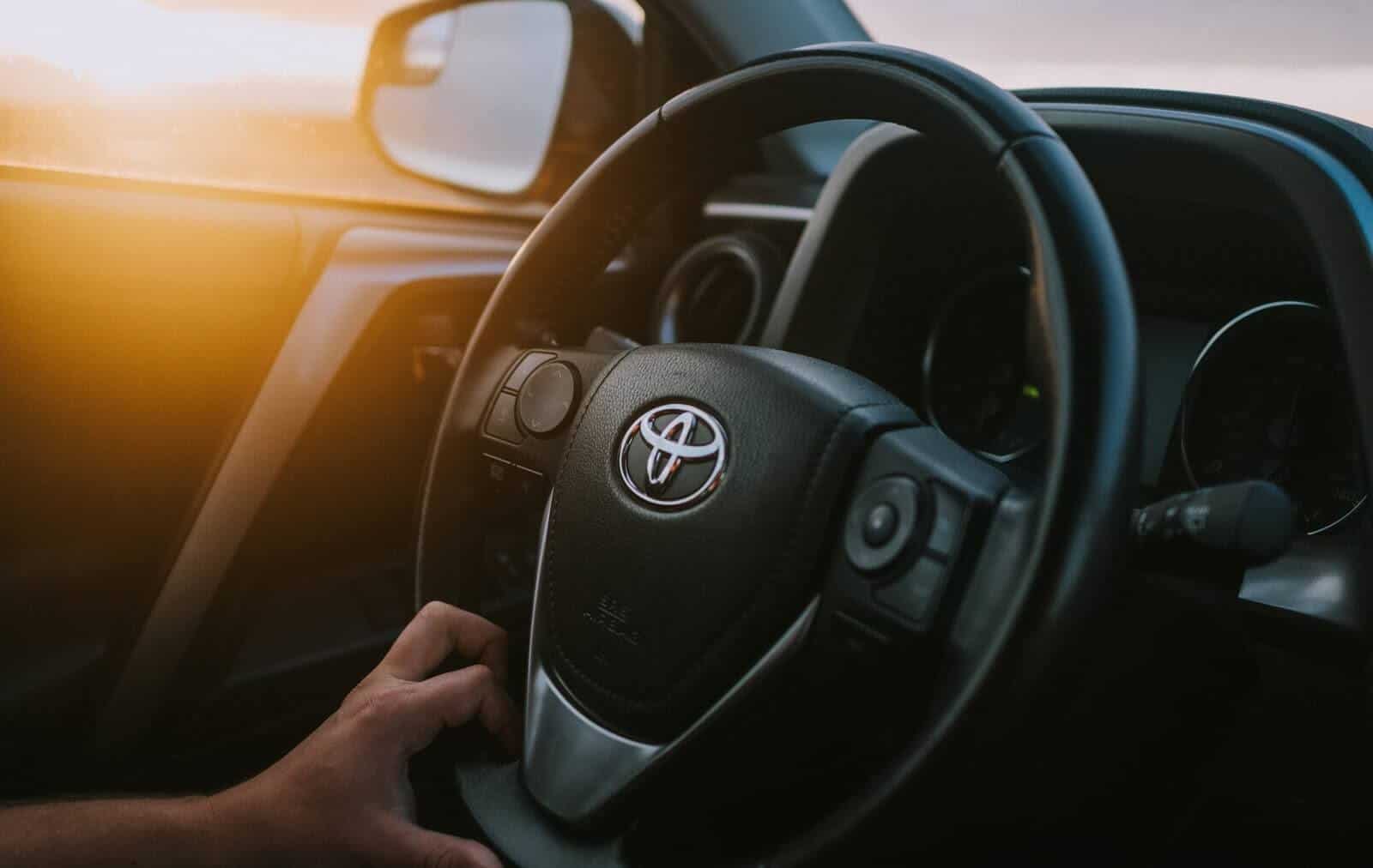 Person's hand on Toyota steering wheel