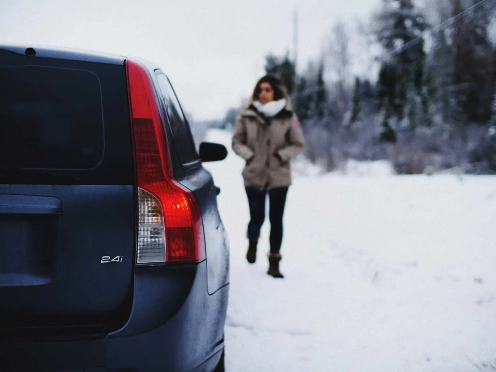 Woman walks toward car in the snow