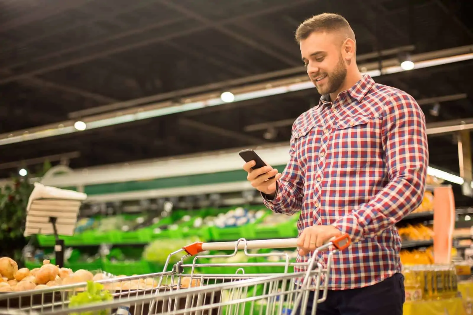 Instacart phone number: A shopper in a grocery store makes a phone call