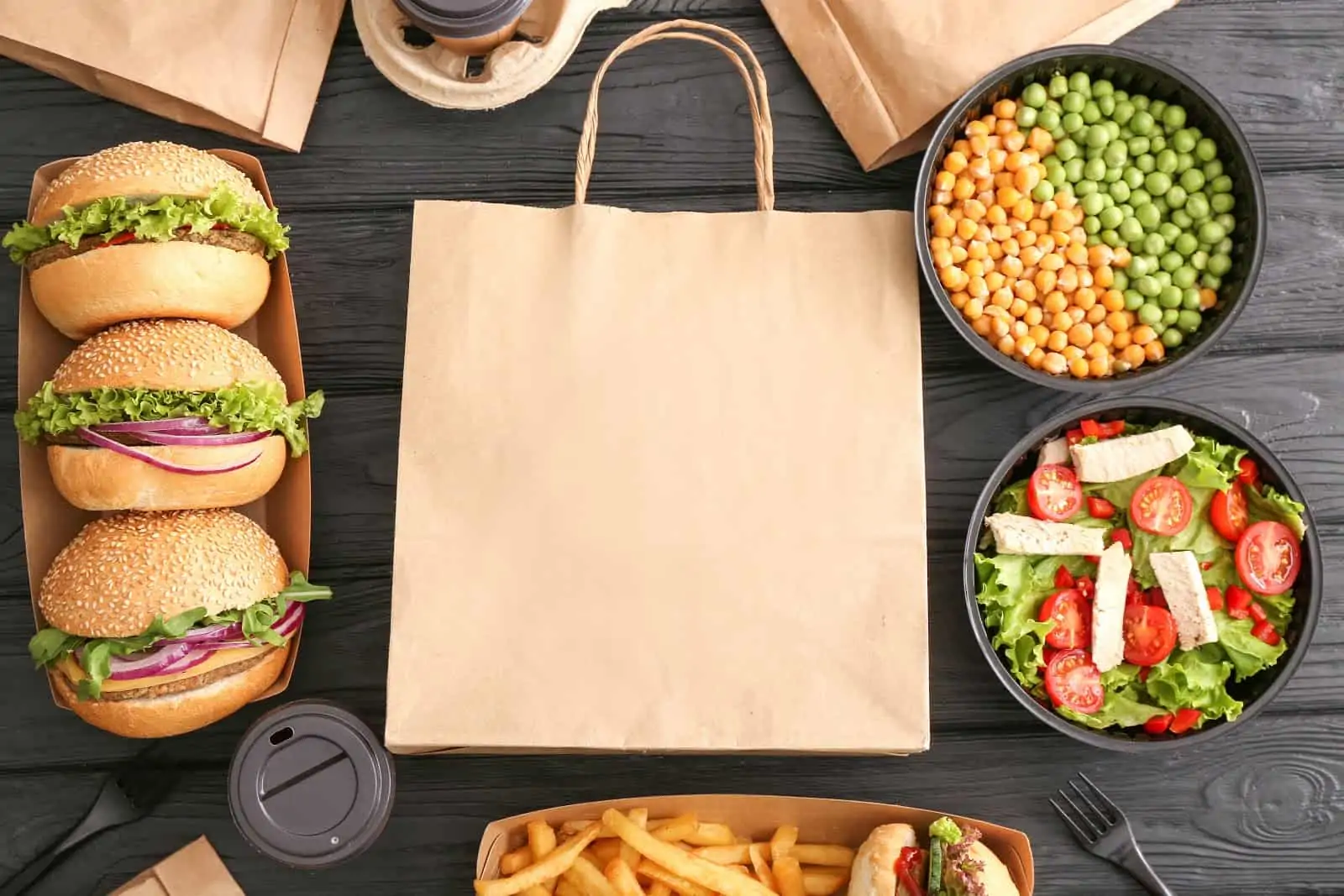 Postmates tipping: Brown paper bag surrounded by takeout food