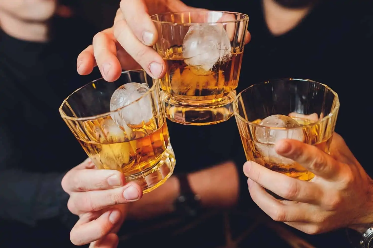 Alcohol delivery apps: People clinking glasses of whiskey together