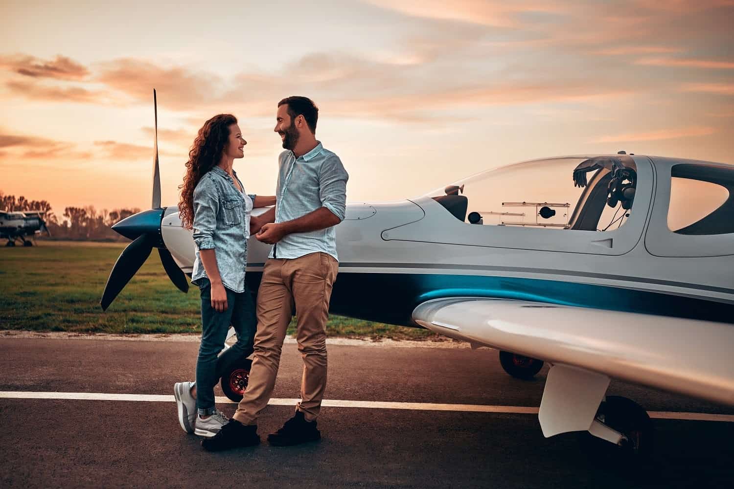 Couple standing by a rented private jet