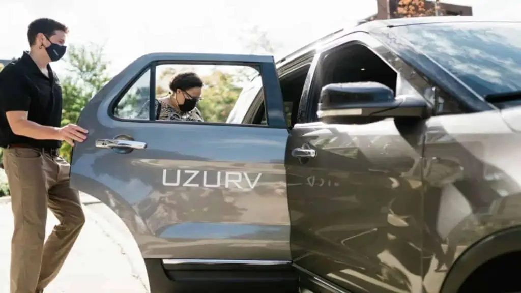 image showing a UZURV driver opening the rear passenger door for a rider to get in the vehicle