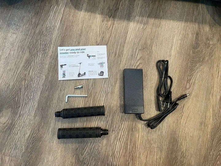 LevyPlus+ electric scooter unboxing - handlebars and charging cord on floor