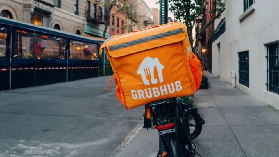 image showing a person on a bike with a grubhub delivery bag on their back - header graphic for how to drive for grubhub post