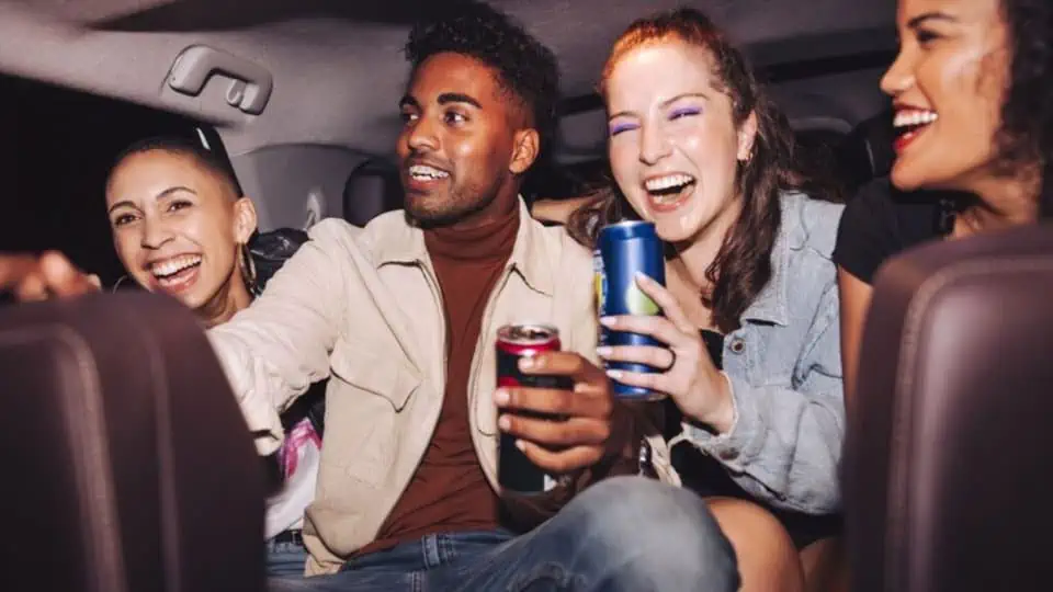 header graphic for Uber New Year's Eve pricing post showing people sitting in the back of a rideshare ride