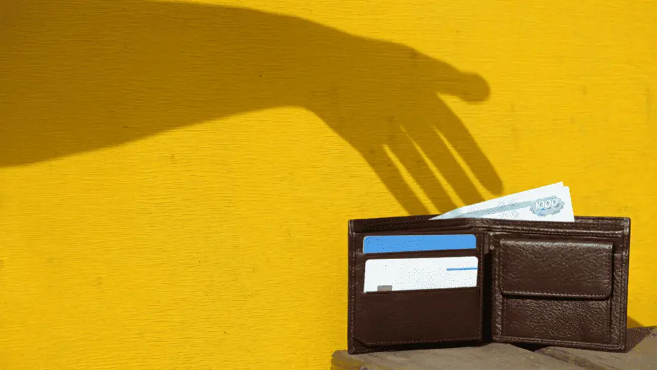 image showing a shadow of a hand reaching into a wallet as if to take money from the wallet - header graphic for tip baiting post on ridester.com